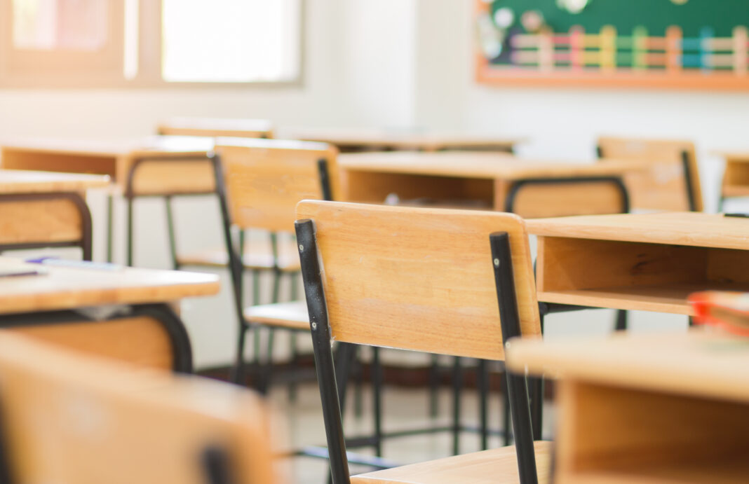 Chair in empty classroom, lecture armchairs in school, or colleg