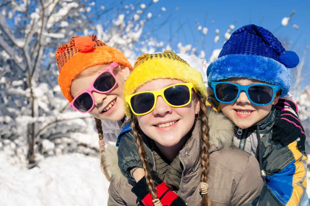 Happy little children playing  in winter snow day.