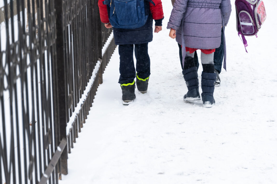 In winter, children return home from school.