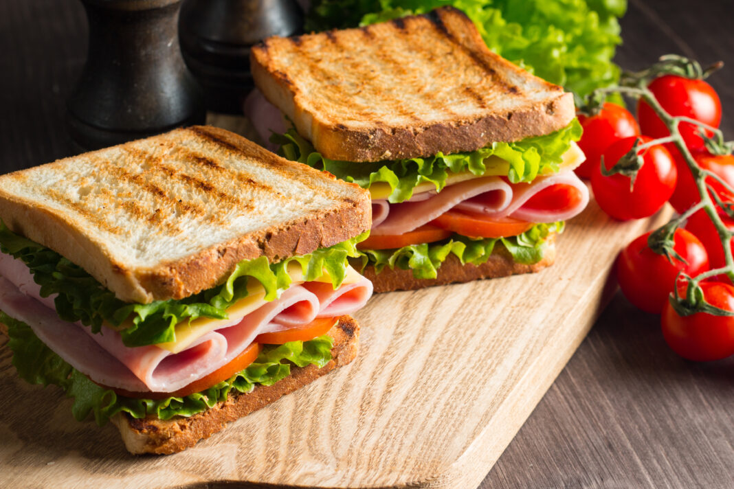 Close-up of two sandwiches with bacon, salami, prosciutto and fr