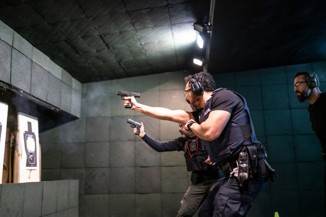 Police training in shooting gallery with short weapon.