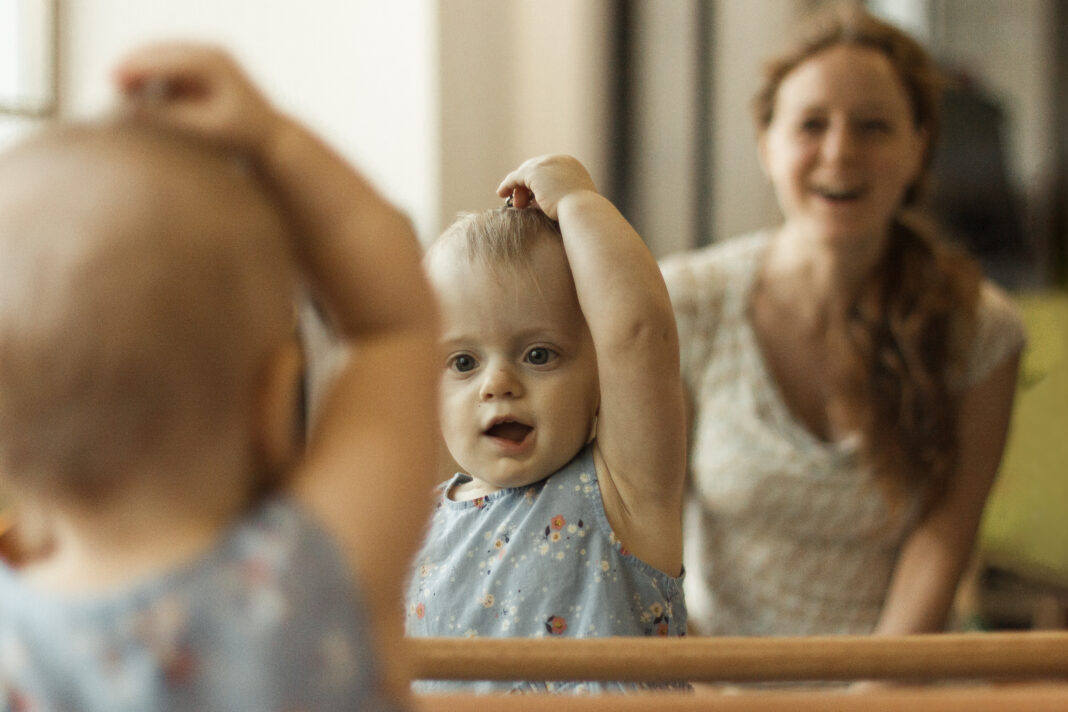mother and her daughter in front of the mirror