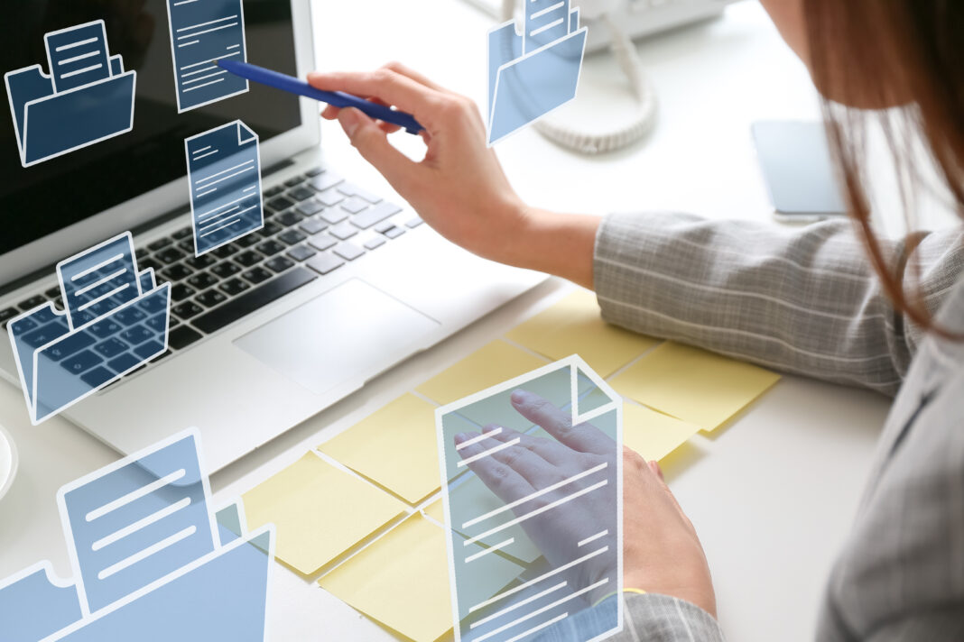 Young businesswoman with sticky note papers, laptop and digital