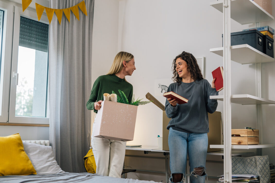 female college student move in dorm. they are talking in the roo