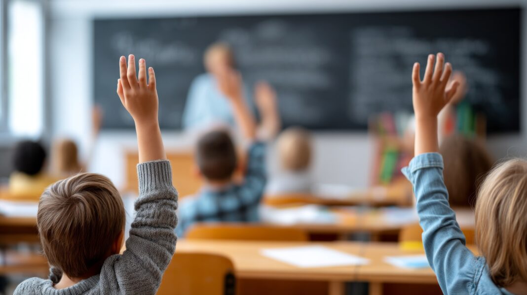 A classroom with students raising their hands